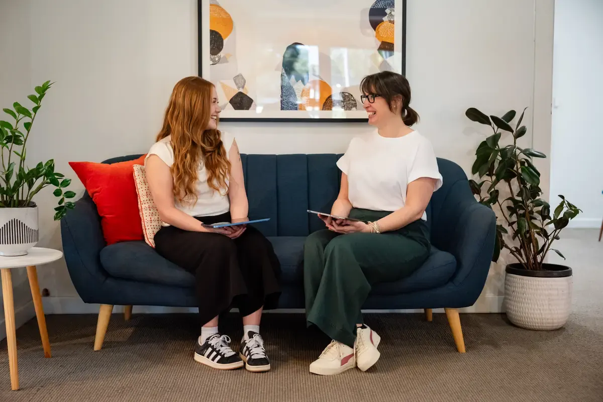 Abella and Jo R chatting on the lounge at The Chiro Crew in Kingswood