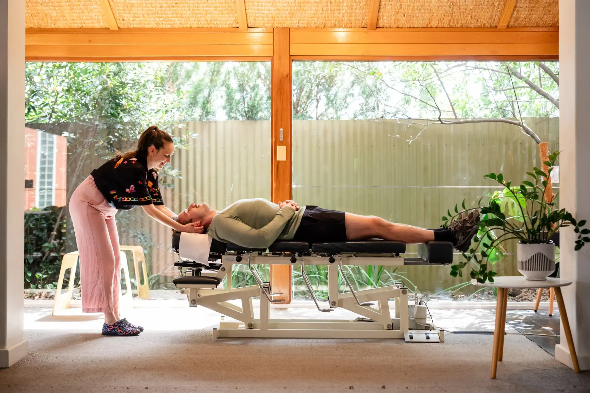 Dr Adelle Semmler adjusting a person on the table in the sunlit room at The Chiro Crew in Kingswood