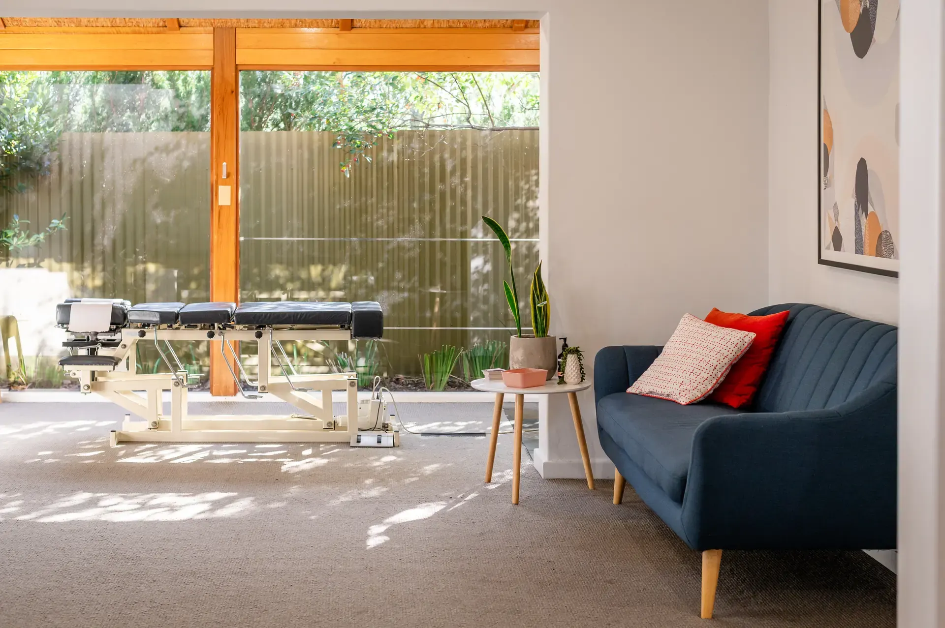 Adjusting table and lounge in the sunlit garden room at The Chiro Crew in Kingswood